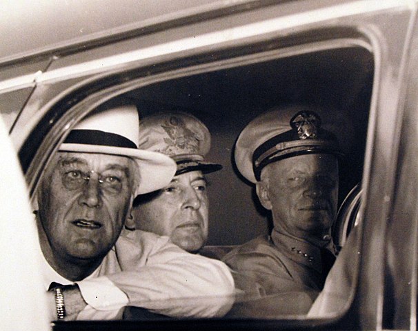 80-G-46234: President Franklin D. Roosevelt visits Pearl Harbor, Territory of Hawaii. Close-up of the President’s car, taken as Mr. Roosevelt peered from the window. In the background are General Douglas MacArthur and Admiral Chester W. Nimitz. Released August 10, 1944. U.S. Navy Photograph, now in the collections of the National Archives. (2016/07/05). FDR Day by Day for July 27, 1944