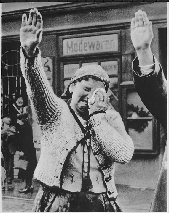 The tragedy of this Sudeten woman, unable to conceal her misery as she dutifully salutes the triumphant Hitler, is the - NARA - 535891.jpg
