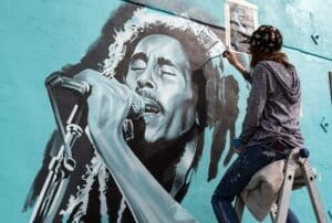 artist painting a mural of bob marley